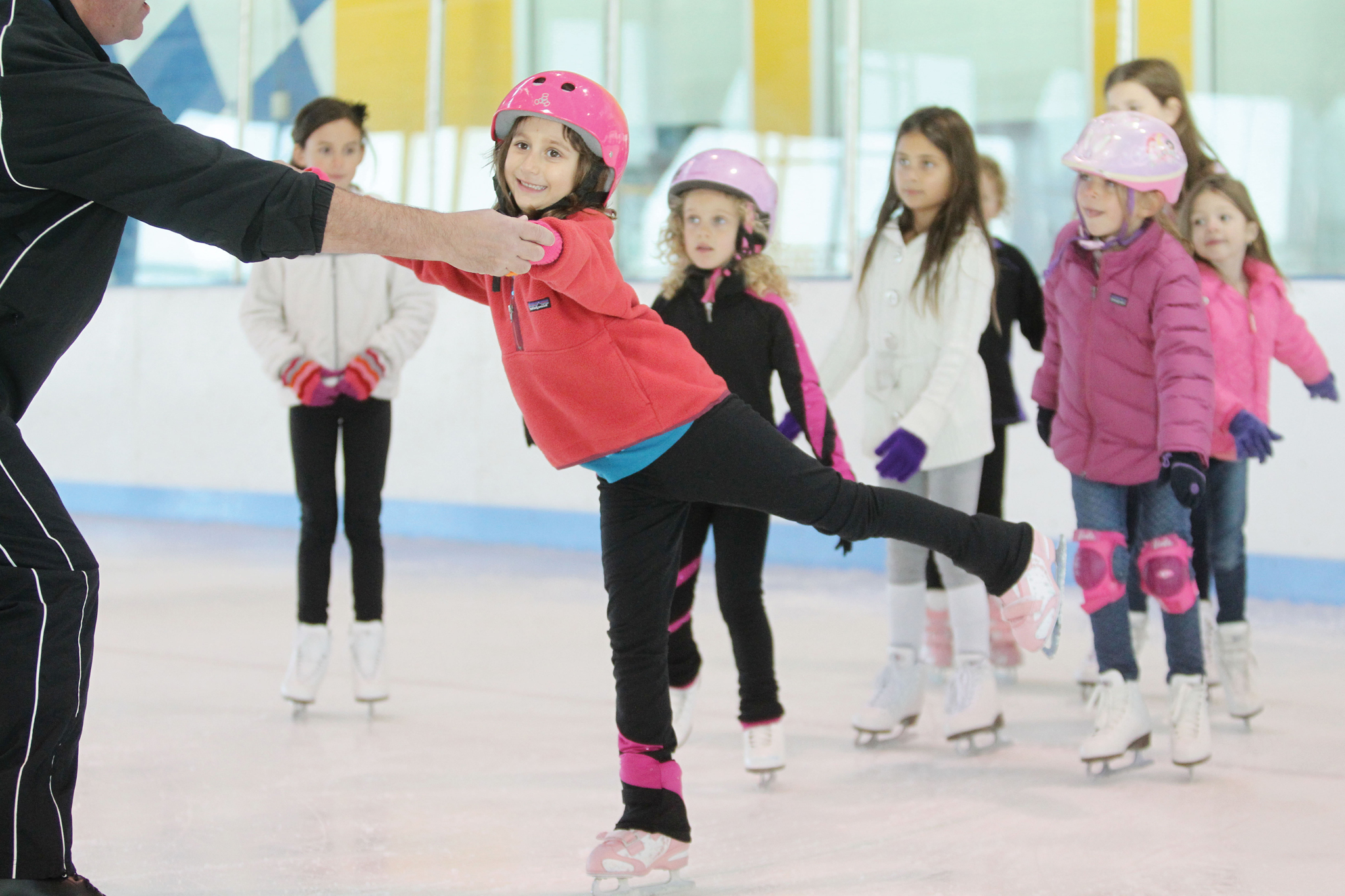 Kids learning to ice skate with instructor